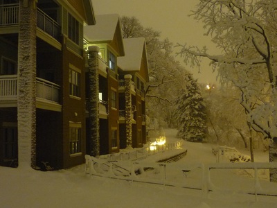 Picture of snow on ground and on buildings around evening