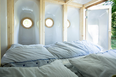 The inside of a pop-up bedroom made up of 16 bath tubs