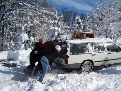 Picture of people pushing a car in the snow