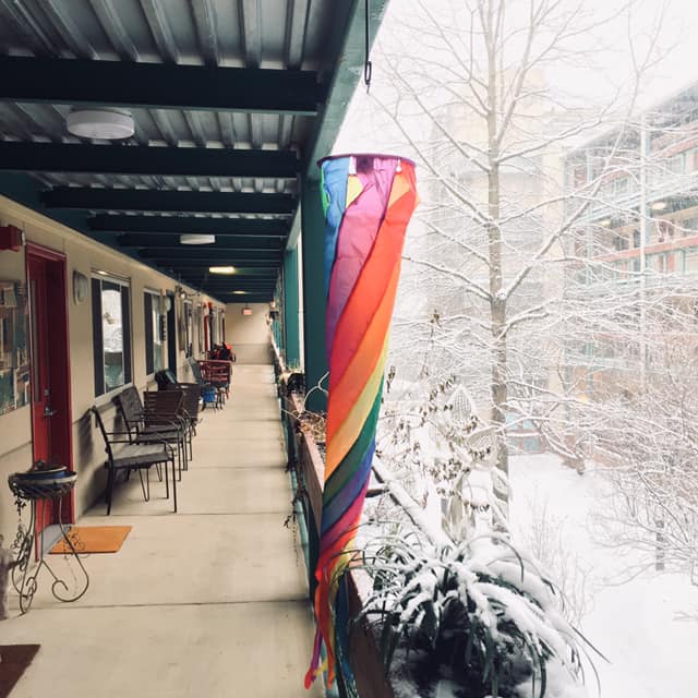 Rainbow flag on balcony with snow in background